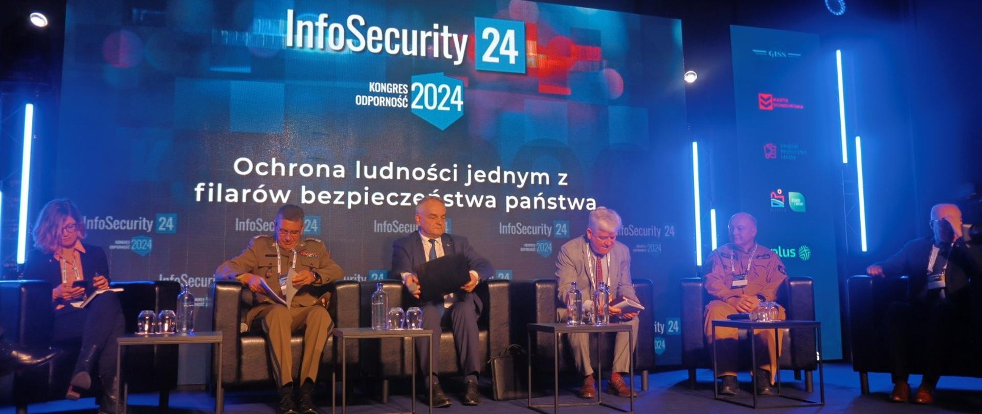 Paneliści siedzący na scenie