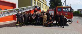 Uczestnicy szkolenia - strażacy PSP i OSP na wspólnym zdjęciu przed drabiną mechaniczną ustawioną przed remizą OSP Kadłub.