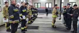 W prawej części zdjęcia Komendant, Prezes OSP i towarzyszący funkcjonariusze wręczają zaświadczenie kursantce. W prawej części zdjęcia strażacy kursanci stoją w dwuszeregu.