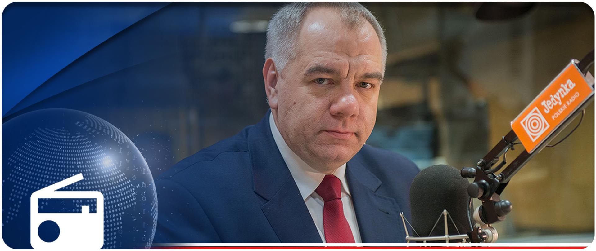 Wicepremier Jacek Sasin przy mikrofonie w audycji Otwarte Karty. W lewym dolnym rogu ikonka radia. 