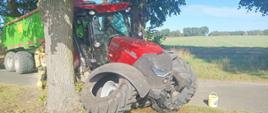 Rozbity na drzewie czerwony ciągnik rolniczy