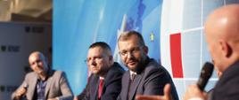 Minister funduszy i polityki regionalnej Grzegorz Puda podczas panelu dyskusyjnego na Forum w Karpaczu. Na pierwszym planie mężczyzna z mikrofonem.