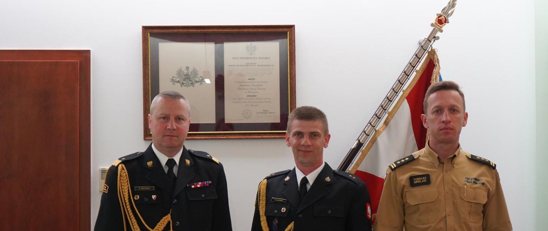 Zdjęcie komendantów wojewódzkich z wyróżnionym strażakiem Karolem Kajewskim 