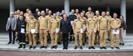 Pamiątkowe zdjęcie grupowe funkcjonariuszy PSP będących uczestnikami szkolenia z zakresu awaryjnego rozładunku cystern (24 osoby) w towarzystwie Zastępcy Komendanta Centralnej Szkoły PSP, kobiety, dwóch funkcjonariuszy CS PSP oraz wykładowcy