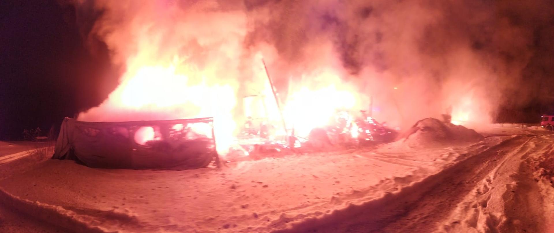 Zgliszcza stodoły stojące w płomieniach.