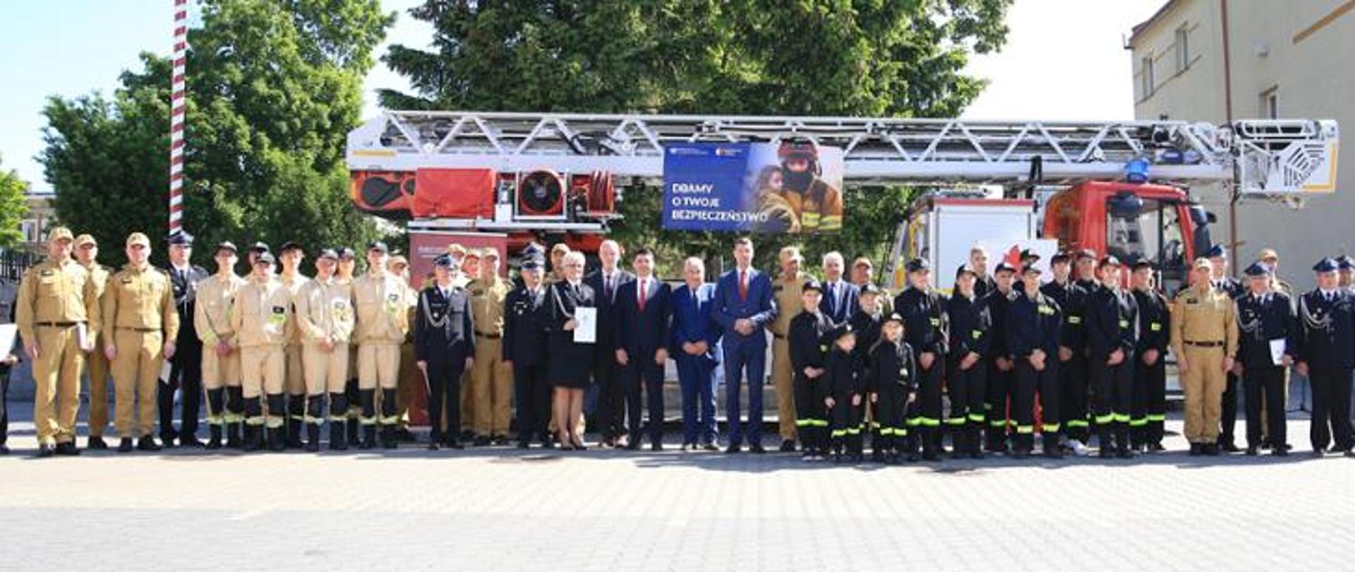 Zdjęcie grupowe na tel samochodu pożarniczego drabiny