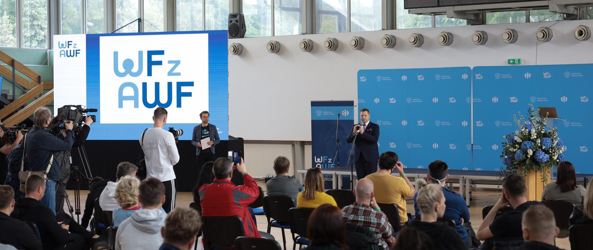 Tłum ludzi siedzących na krzesłach i słuchający przemówienia ministra Edukacji i Nauki Przemysława Czarnka podczas inauguracji szkoleń dla nauczycieli – „WF z AWF”. 