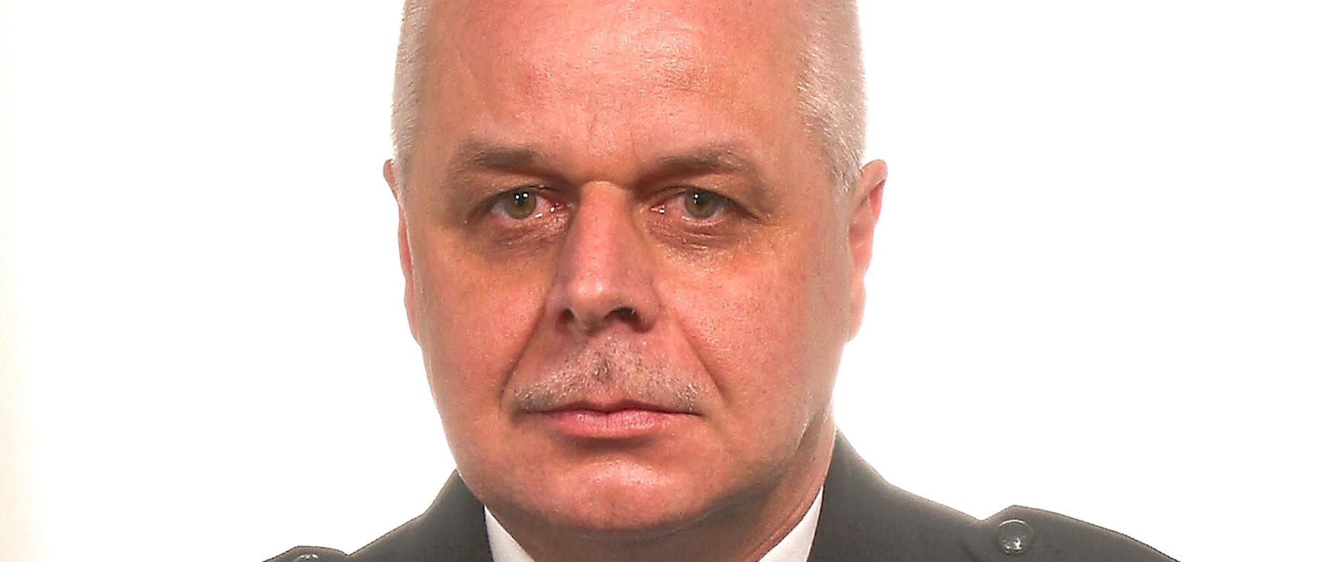 Strażak Państwowej Straży Pożarnej w stopniu młodszego brygadiera, w umundurowaniu wyjściowym ze sznurem galowym.