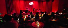 band jazzowy gra na scenie klubu oświetlonego ciemnym, czerwonym światłem