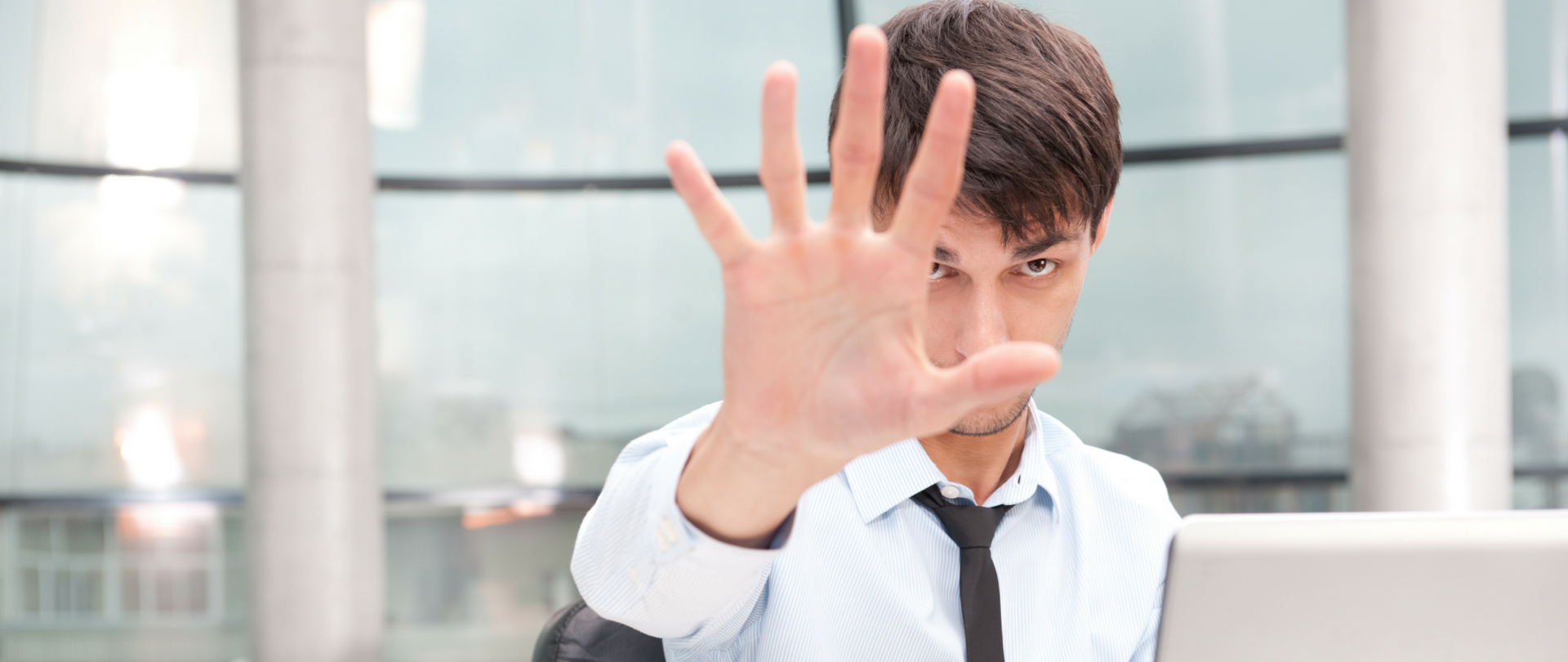 Mężczyzna z wyciągniętą dłonią, zasłaniającą twarz