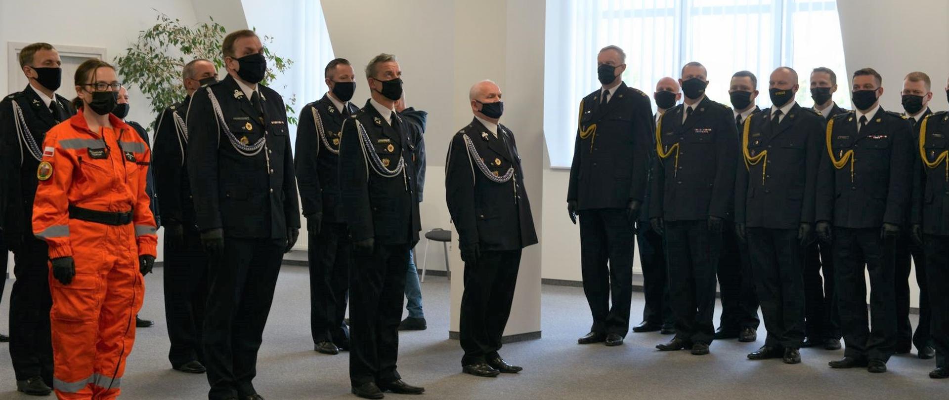 Straży ochotniczej straży pożarnej oraz komendanci miejscy, powiatowi Państwowej Straży Pożarnej stoją podczas uroczystej zbiórki z okazji przekazania promes.