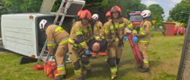 Ćwiczenia z zakresu ratownictwa technicznego. Zdjęcie przedstawia strażaków PSP oraz OSP podczas ewakuacji poszkodowanych z pojazdu.