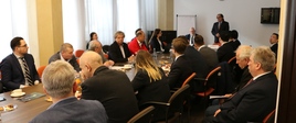 Uczestnicy spotkania przy stole. Przemawia min. M. Gróbarczyk