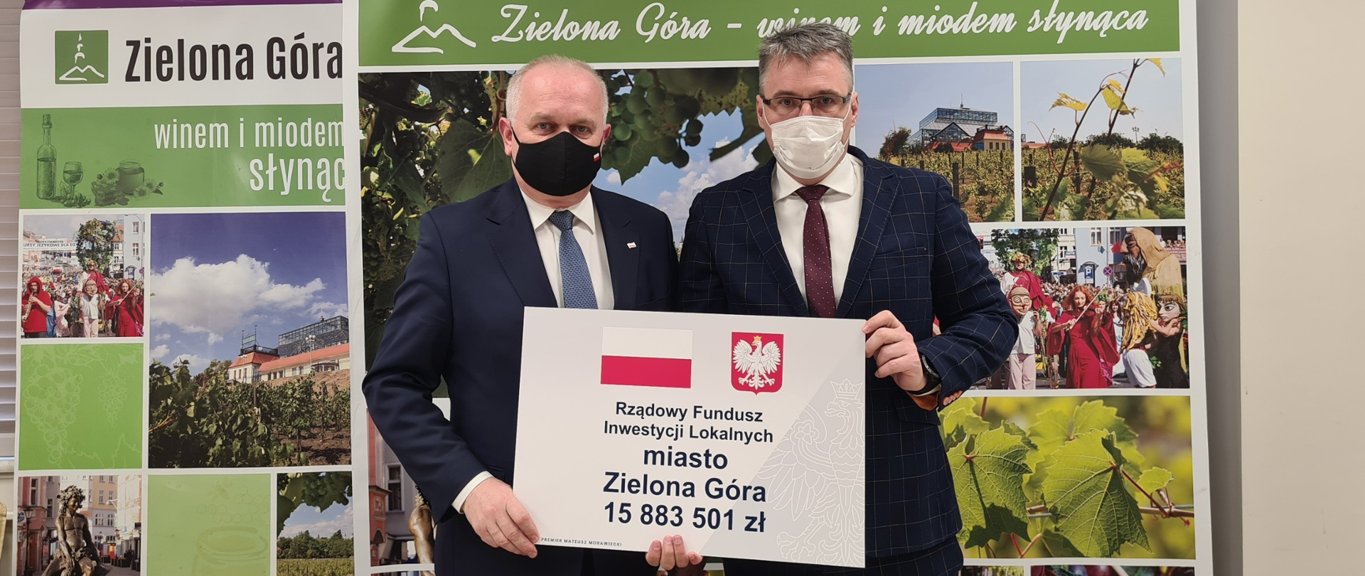 Wojewoda Władysław Dajczak z Prezydentem Zielonej Góry Januszem Kubickim stoją na tle ścianki promocyjnej miasta. Obaj trzymają czek z napisem: Rządowy Fundusz Inwestycji Lokalnych, miasto Zielona Góra, 15 883 501 zł