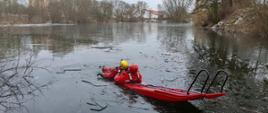 Na zdjęciu widać strażaków ćwiczących ratownictwo lodowe na zbiorniku wodnym.