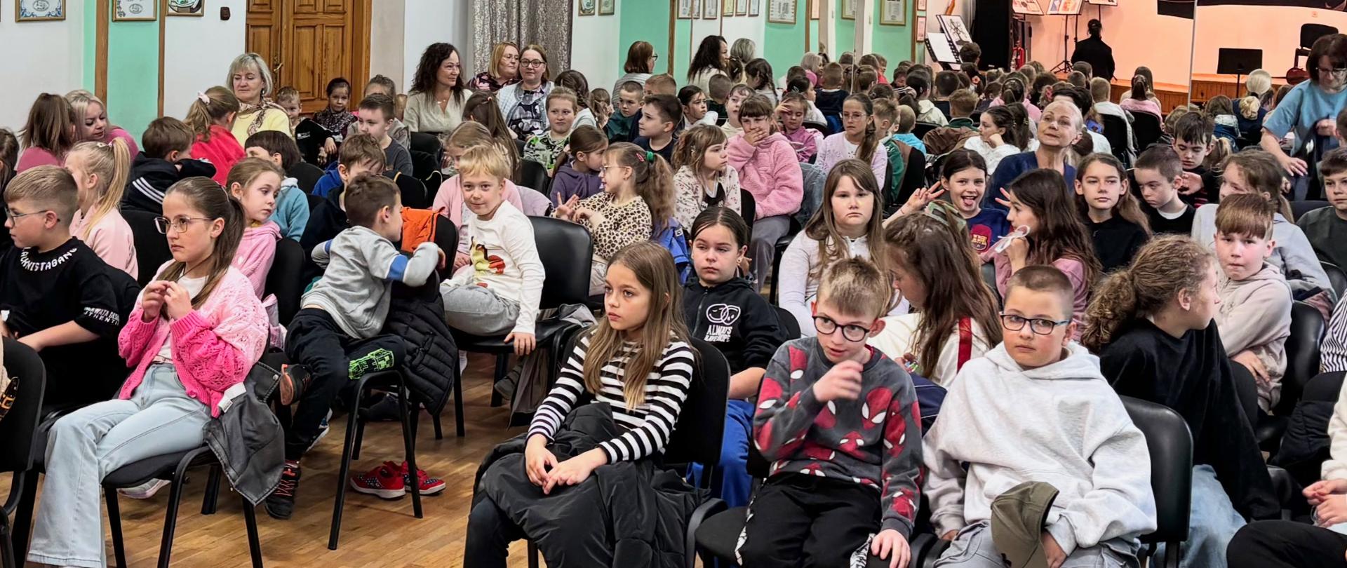 Zdjęcie przedstawiające uczestników koncertów zorganizowanych w ramach poranków muzycznych dla szkół i przedszkoli, które odbyły się 18 maja 2026 roku w auli szkoły
