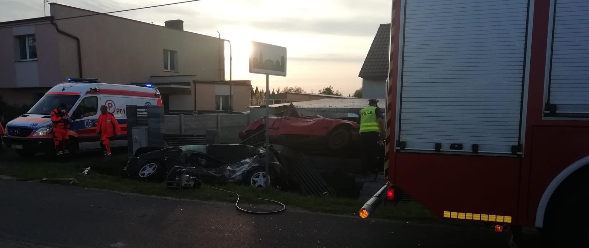 Na zdjęciu widać rozbite pojazdy oraz karetkę pogotowia i wóz strażacki 