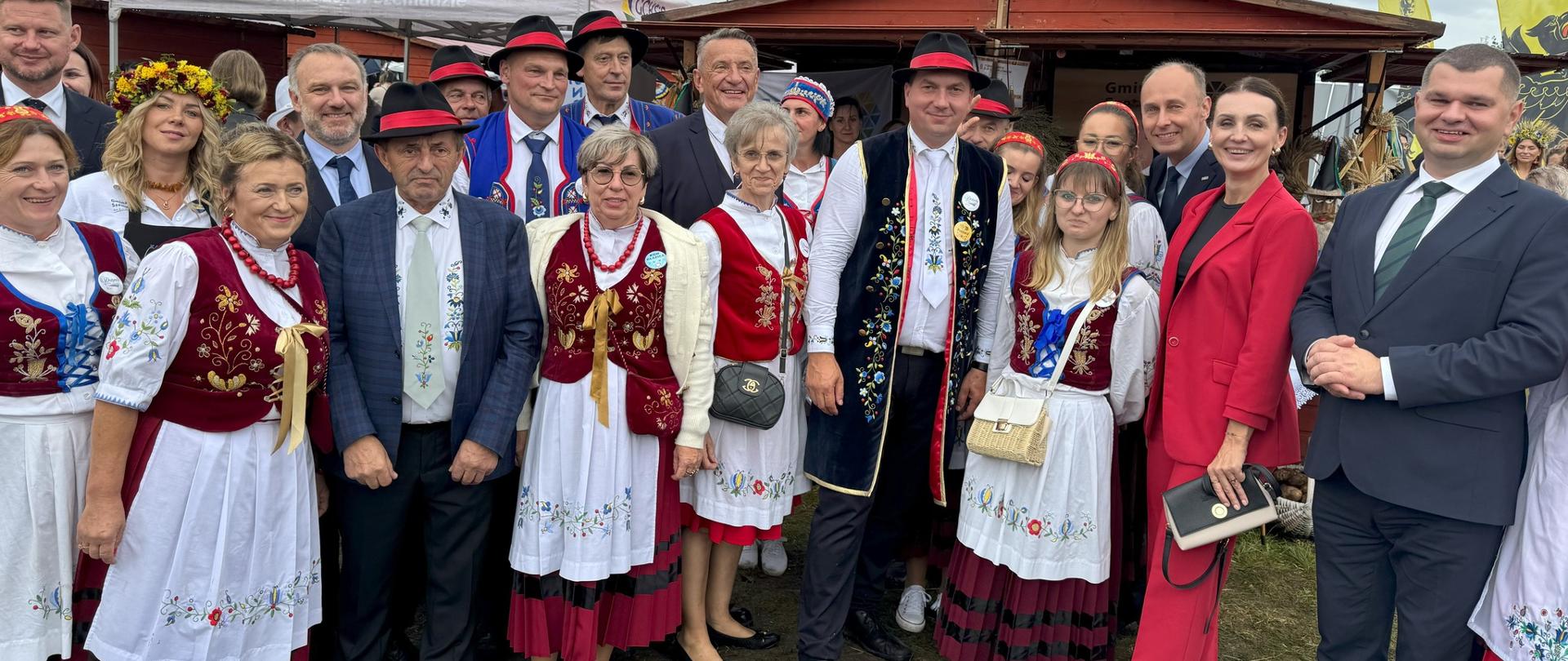 grupa osób pozuje do zdjęcia, część ma na sobie kaszubskie stroje