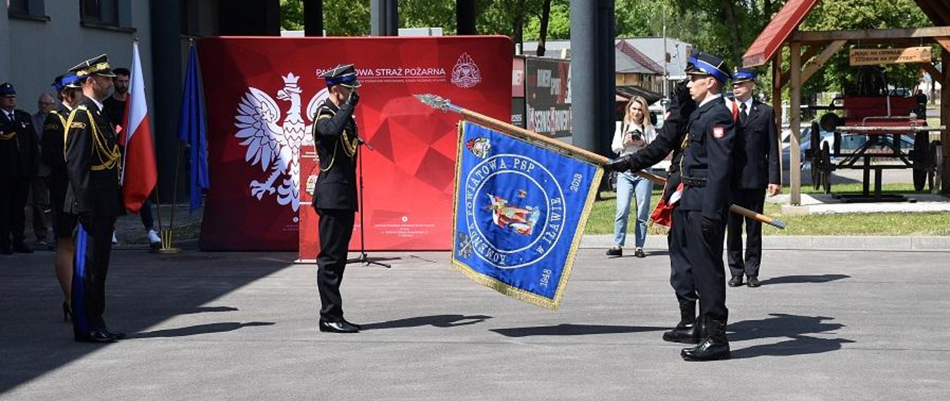 Komendant Powiatowy wita się ze sztandarem. 