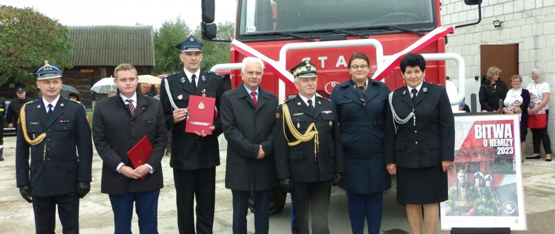 Przekazanie samochodu pożarniczego dla Ochotniczej Straży Pożarnej w Kiełpińcu (gm. Sterdyń) - na zdjęciu osoby po wręczenia aktu przekazania i kluczyków do samochodu.