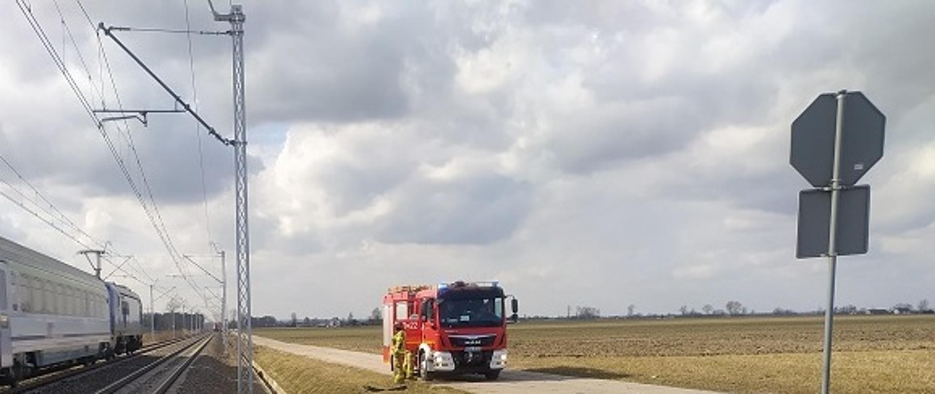 Zdjęcie przedstawia samochód osobowy po wypadku drogowym na przejeździe kolejowym