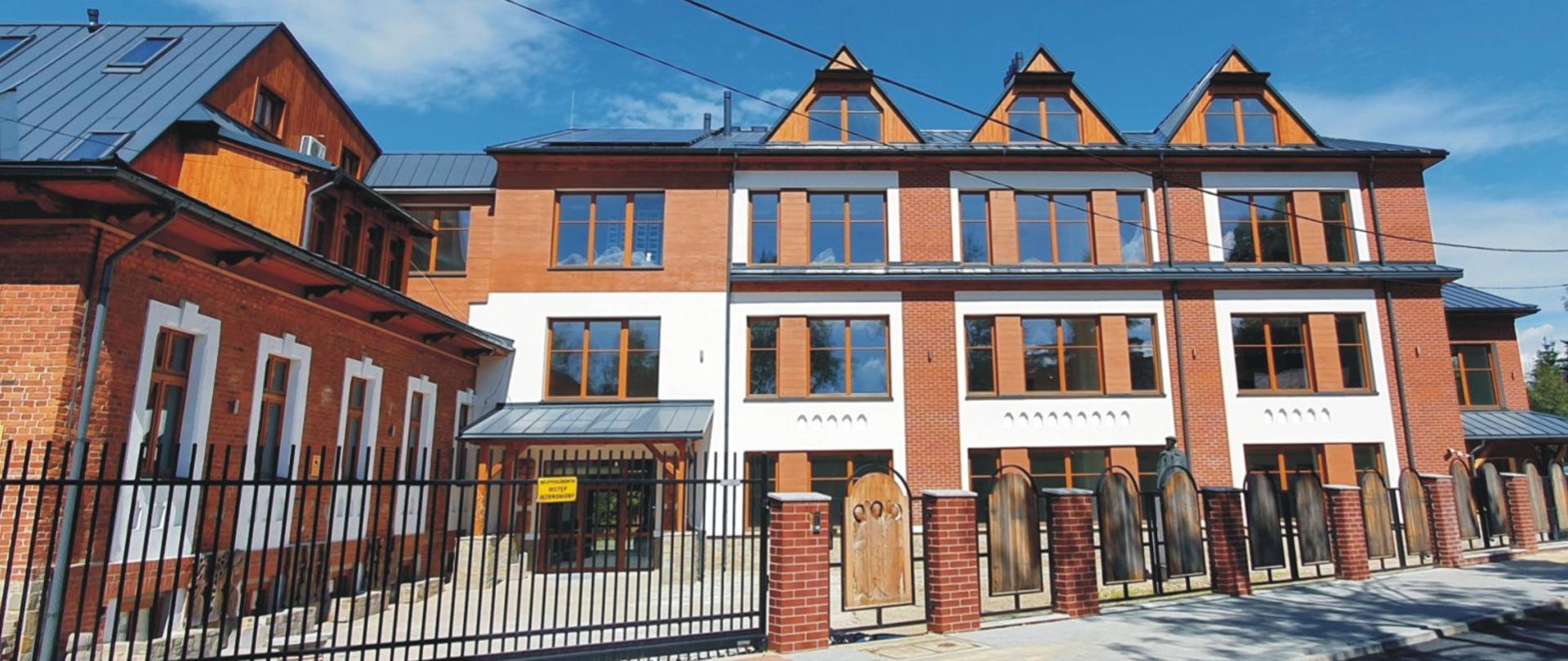 Na grafice znajdują się dwa zdjęcia jedno pod drugim na których przedstawiony jest budynek głównej siedziby szkoły "Strug" mieszczący się przy ul. Kościeliskiej 35. U góry widzimy budynek szkoły po remoncie z umieszczonym w prawym górnym rogu rokiem 2024. na dole grafiki mamy drugą fotografię z budynkiem szkoły w trakcie remontu. Na fotografii w prawym górnym rogu widzimy datę 2021 rok