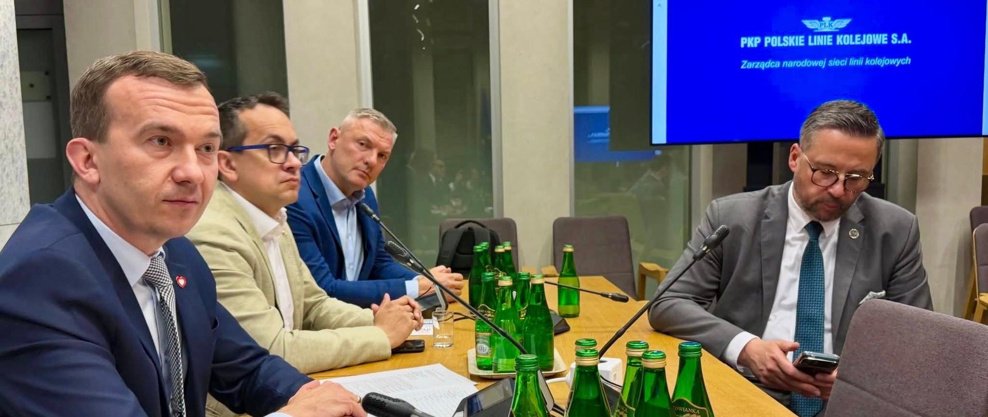 kilkanaście osób siedzi przy stole 