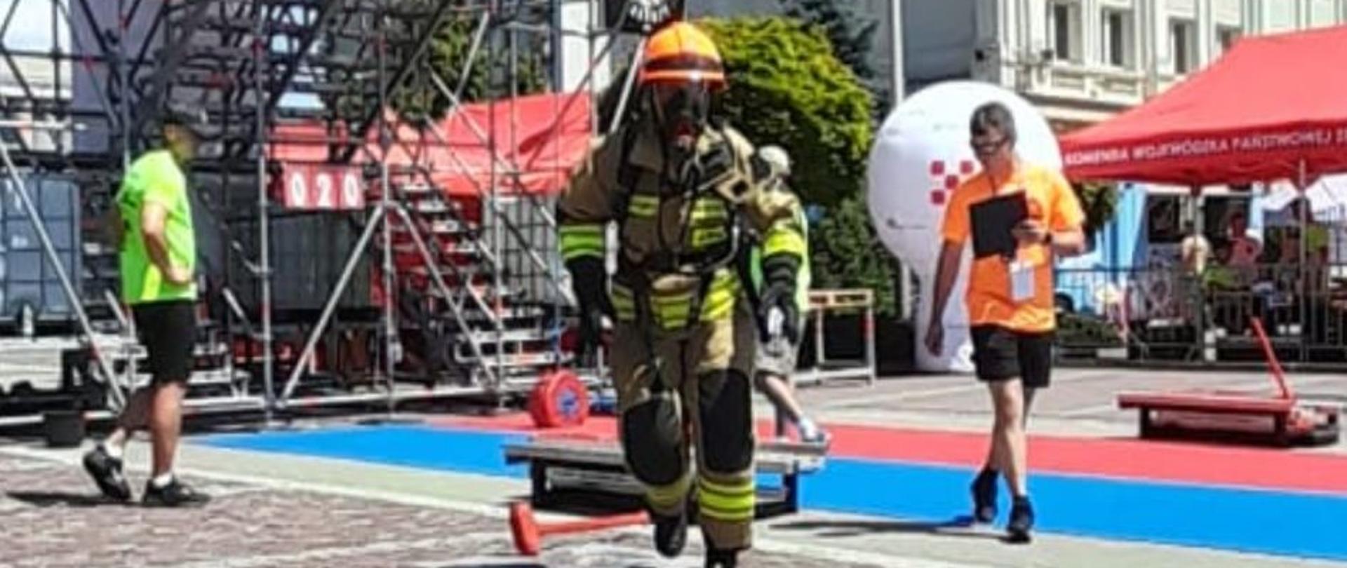 Na zdjęciu st.str. Ewa Dobrzyńska podczas konkurencji, ubrana w ubranie specjalne, hełm oraz aparat ochrony dróg oddechowych