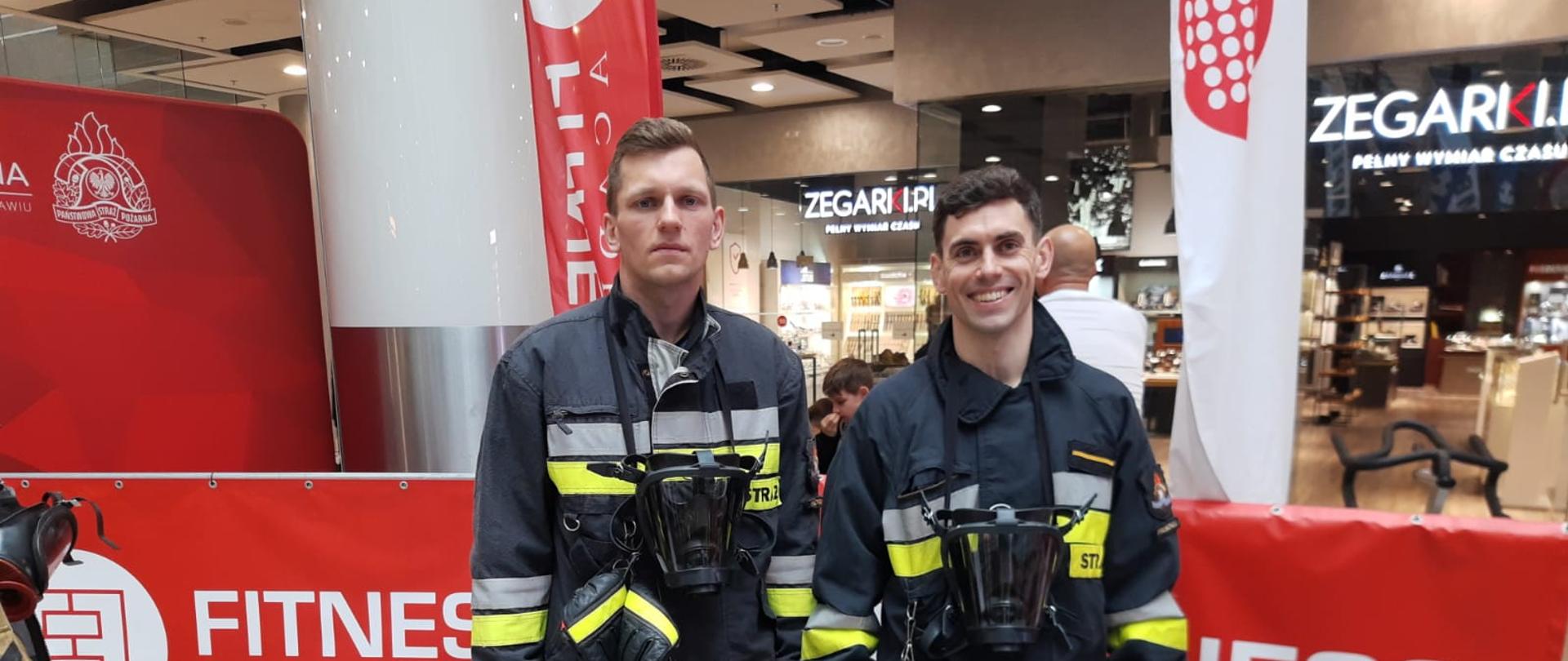 Dwóch strażaków oczekuje na bieg po schodach