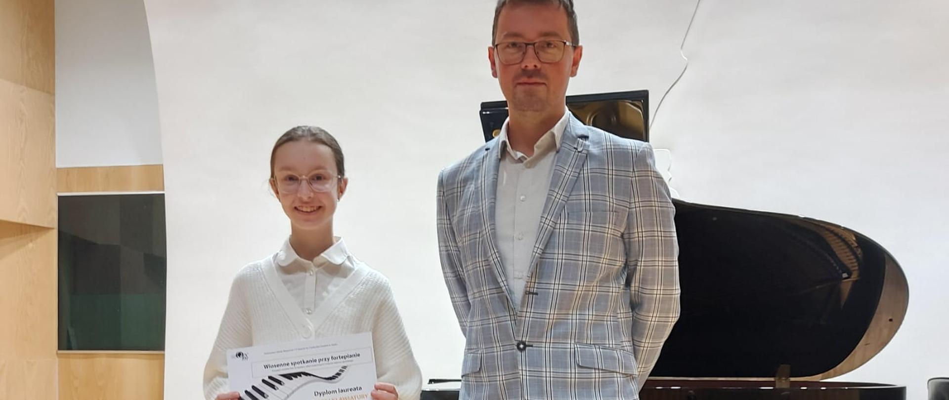 Zdjęcie laureatki Złotej Klawiatury Patrycja Cichoń z nauczycielem fortepianu dr Danielem Rybakiem, stojący na scenie szkoły muzycznej w Opolu