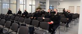 Komendanci miejscy, powiatowi Państwowej Straży Pożarnej siedzą podczas narady.