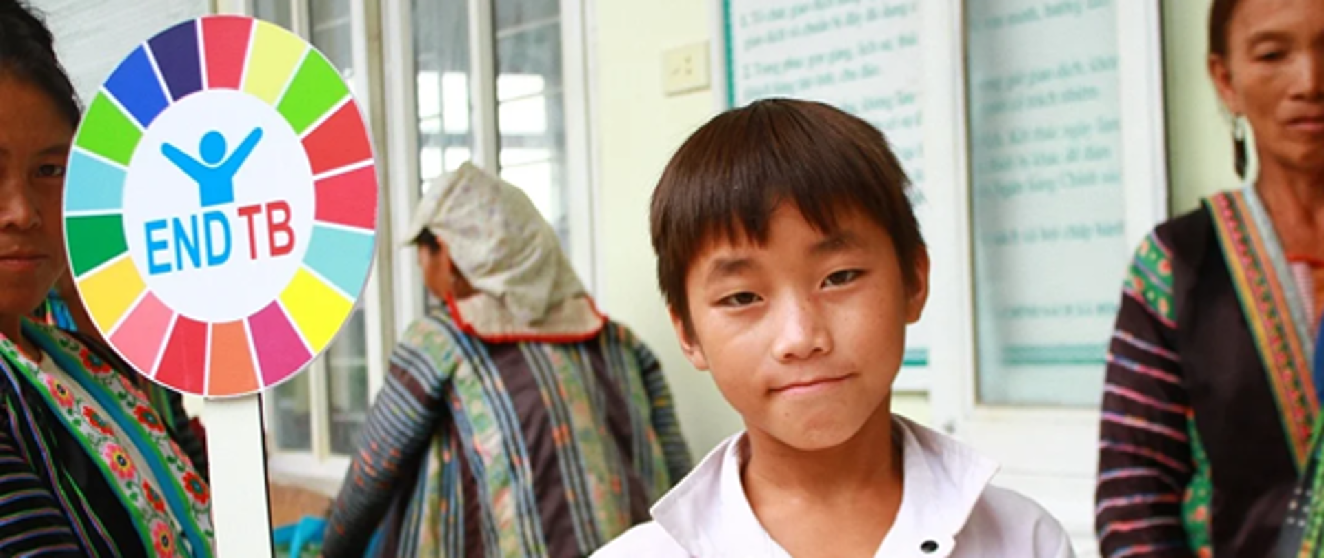 Na zdjęciu jest przedstawiony chłopiec, który trzyma w ręce transparent z napisem END TB