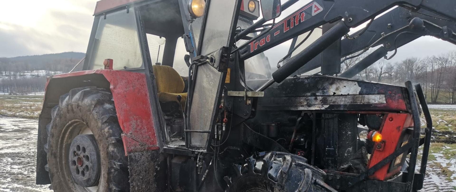 Na zdjęciu widoczny ciągnik rolniczy po pożarze komory silnika. Ciągnik koloru czerwonego. Zdjęcie wykonane na terytorium Republiki Czeskiej. 