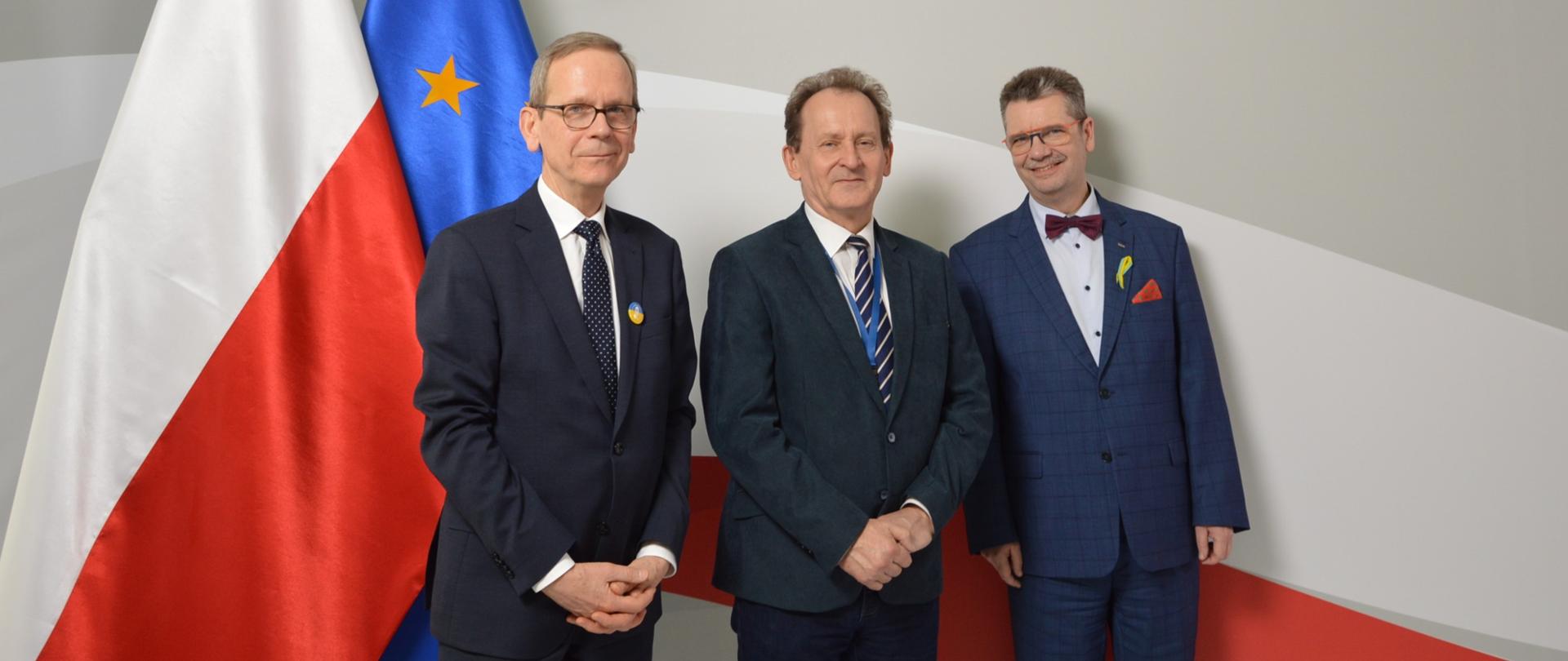 na zdjęciu stoi minister Bernacki. W po jego prawej i lewej stronie stoją rektorzy uczelni ekonomicznych. W tle flaga Polski i Unii Europejskiej. Nad ministrem i rektorami napis szary Ministerstwo Edukacji i Nauki