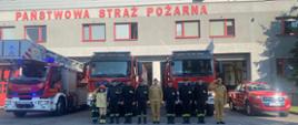 Na zdjęciu widoczni są strażacy na tle samochodów ratowniczo - gaśniczych oddający hołd bohaterom Powstania Warszawskiego