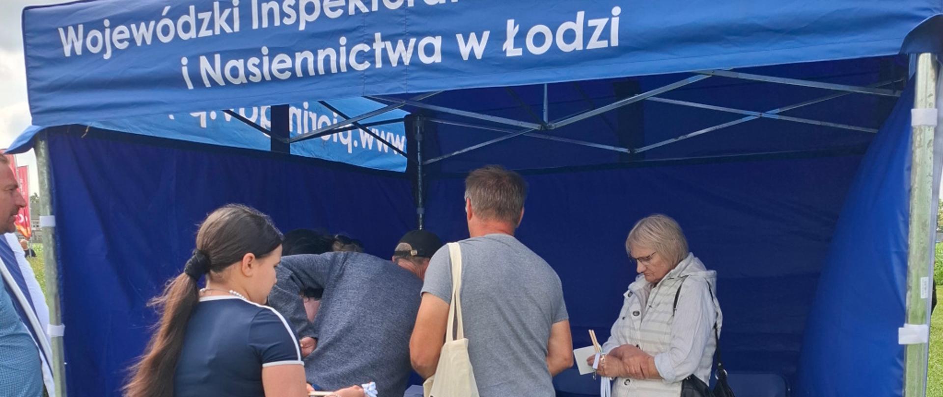 Uczestnicy spotkania z zainteresowaniem pobierają ulotki ze stoiska WIORiN