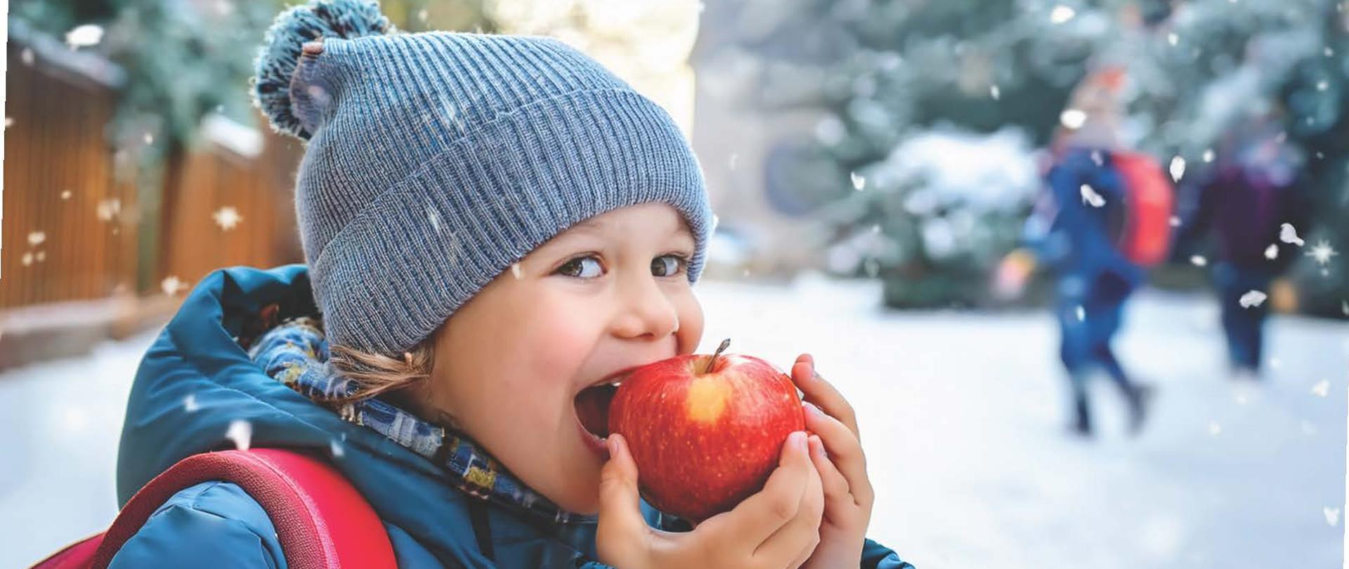 dziecko_z_jabłkiem_zimową_porą