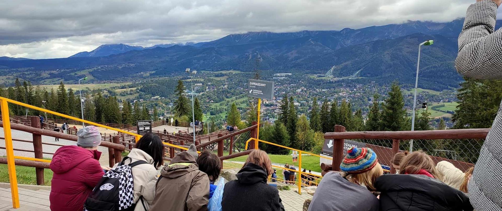 Kolorowo ubrane uczennice siedzą na schodach 