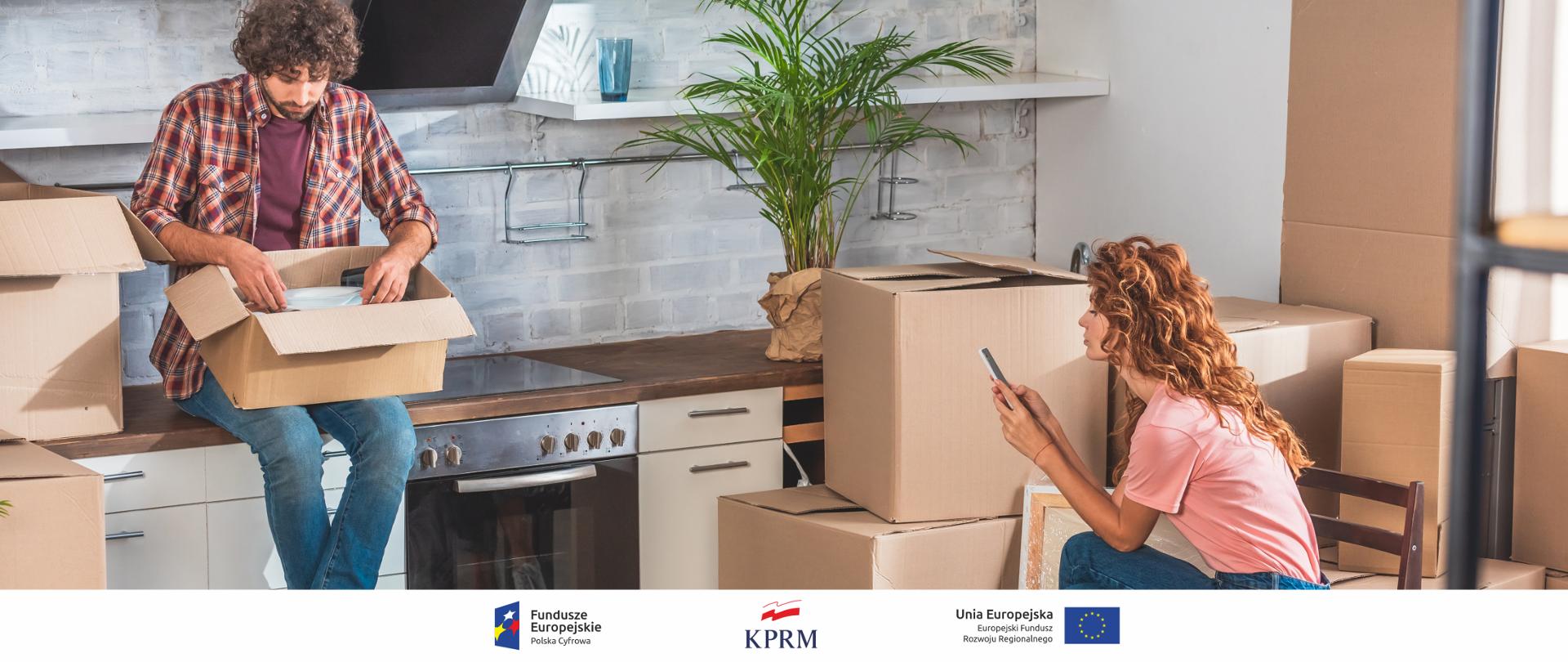 Para - mężczyzna i kobieta - siedzą w kuchni otoczeni pudełkami, które rozpakowują (po wprowadzeniu do nowego mieszkania). Mężczyzna siedzi na blacie kuchennym - ogląda zawartość jednego z pudełek. Kobieta siedzi na krześle, pisze coś na smartfonie.