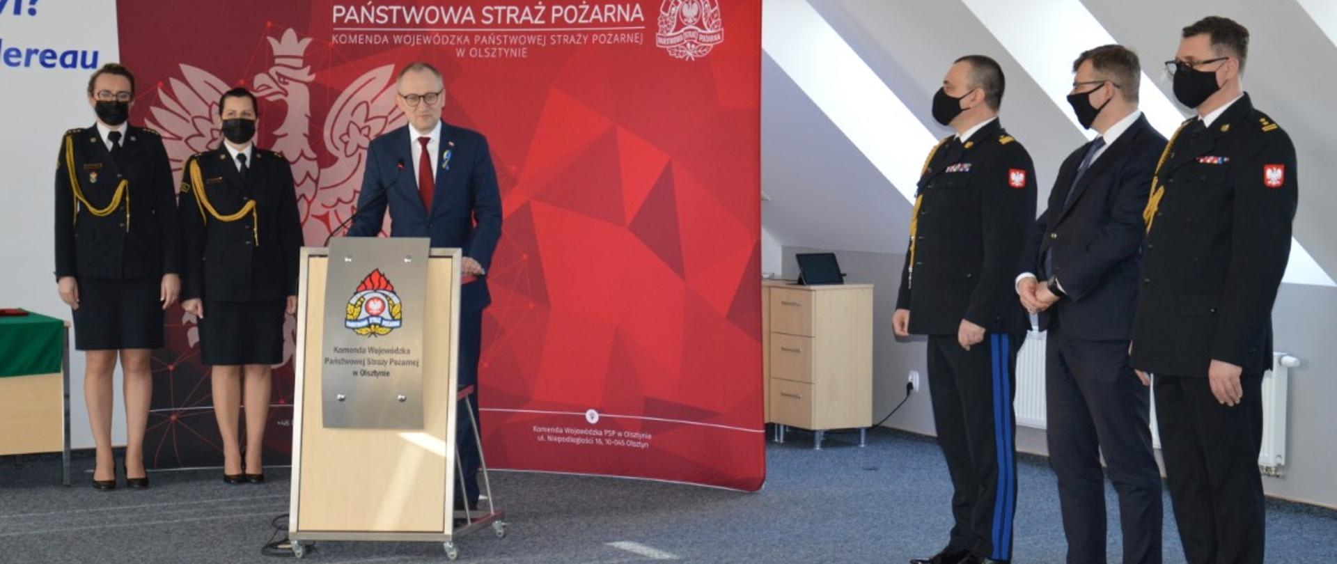 Zdjęcie przedstawia m.in. Podsekretarza Stanu MSWiA przemawiającego do funkcjonariuszy PSP oraz druhów OSP