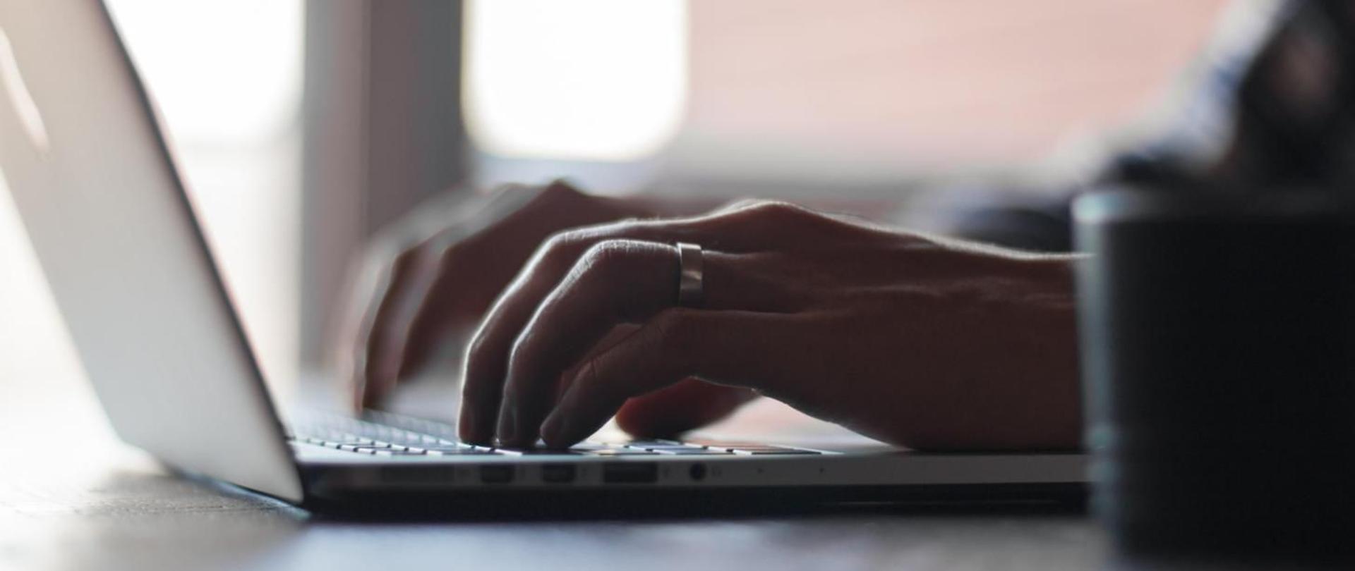 Obraz przedstawiający pracę przy laptopie