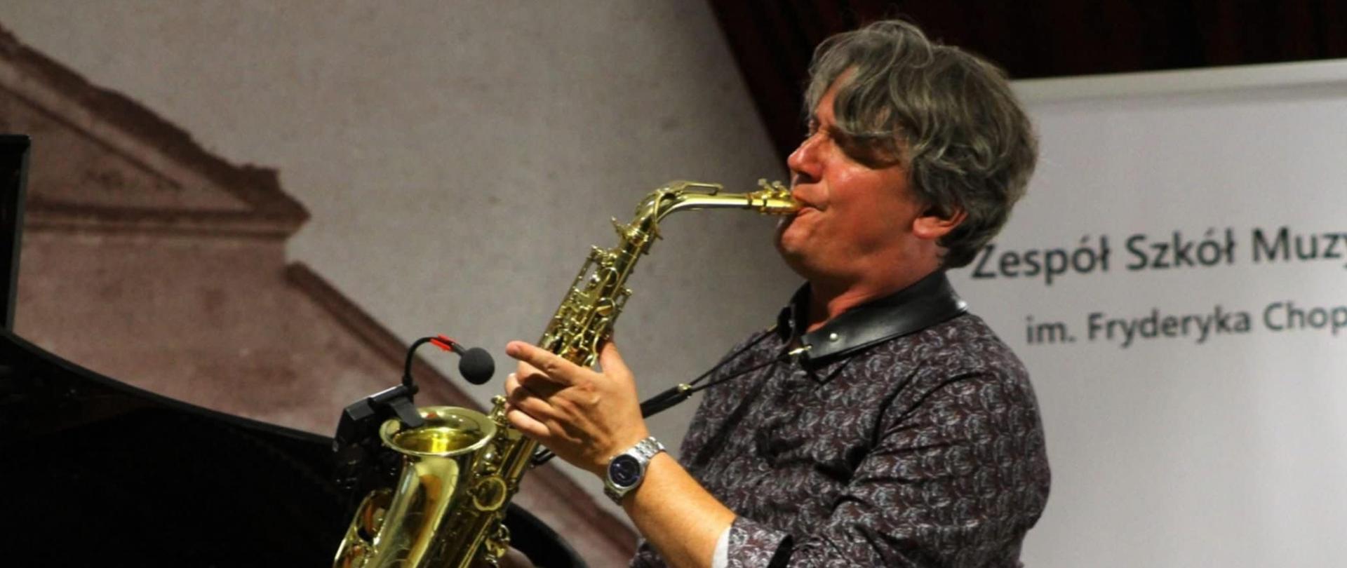 Pan dyrektor Radosław Żyła gra na scenie na saksofonie