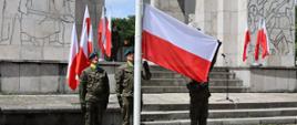 Uroczyste obchody Narodowego Dnia Powstań Śląskich przed Pomnikiem Czynu Powstańczego na Górze Świętej Anny. Na zdjęciu widać podnoszenie flagi na maszt przez żołnierzy. W tle znajduje się Pomnik Czynu Powstańczego na Górze Świętej Anny.