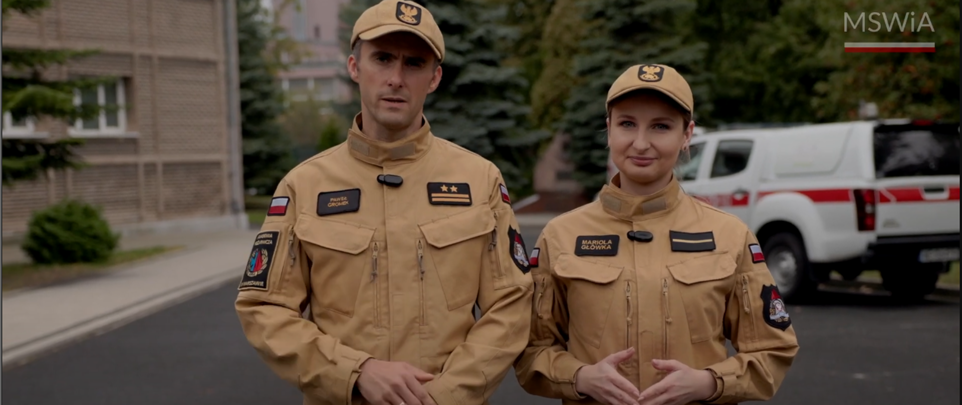 strażak i strażaczka na tle samochodu strażackiego