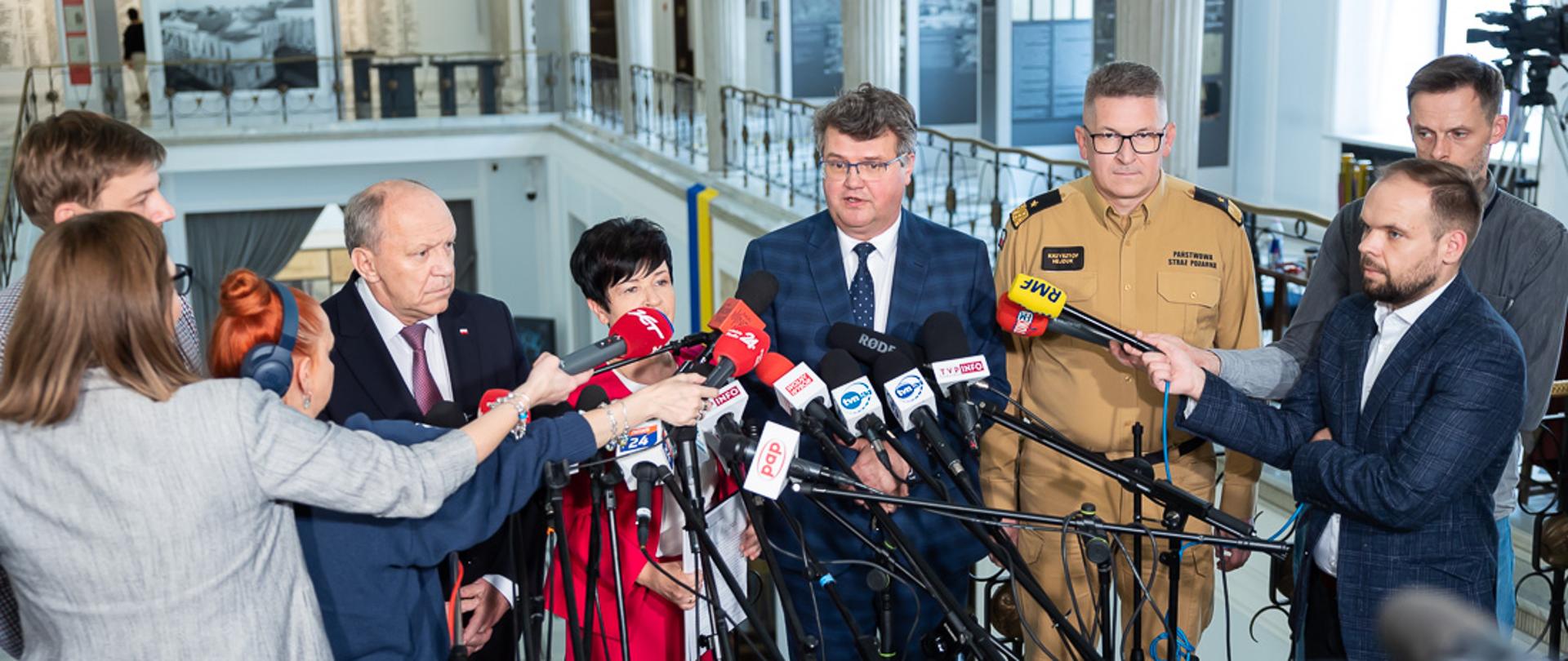 konferencja wiceministra MSWiA oraz zastępcy komendanta Głównego przy mikrofonach wokół inne osoby