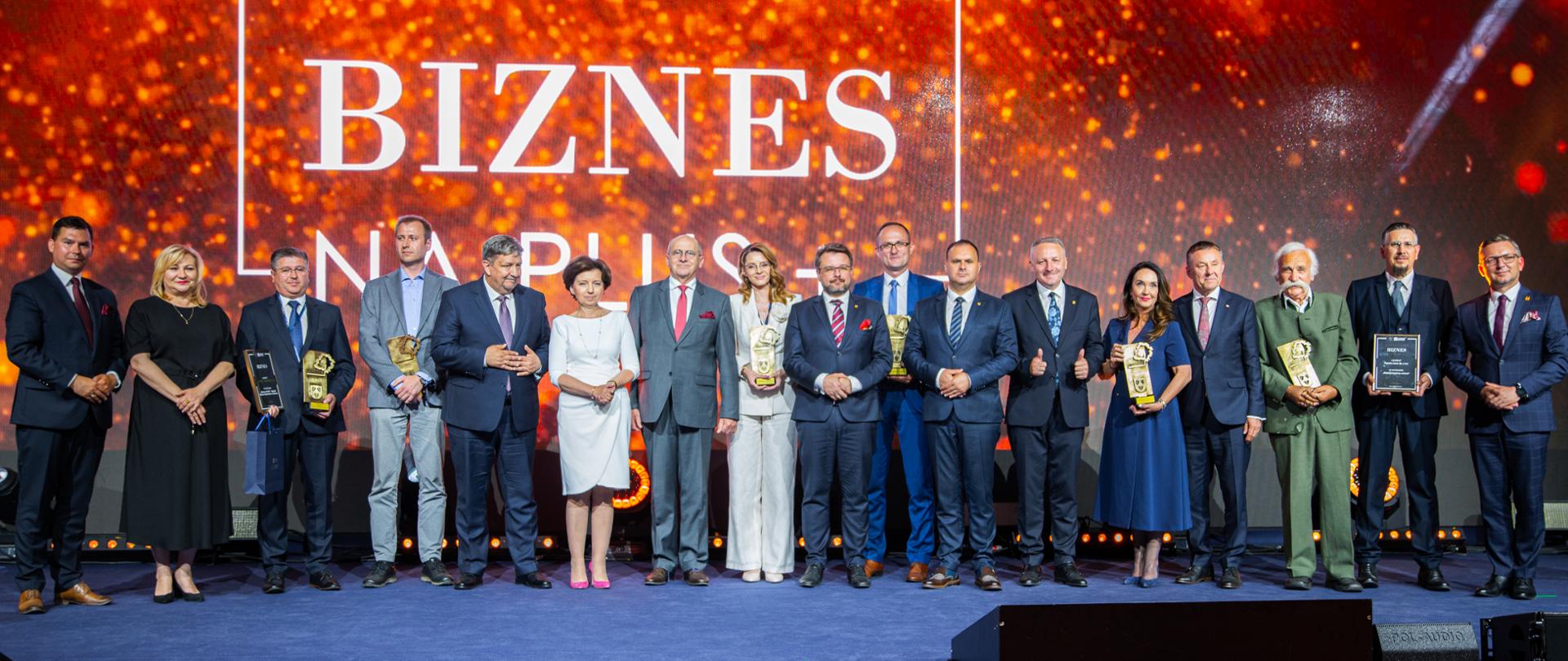 grupa VIP-ów stoi na scenie gali Biznes na plus, m.in. minister spraw zagranicznych, minister rodziny i polityki społecznej, wojewoda łódzki, marszałek województwa