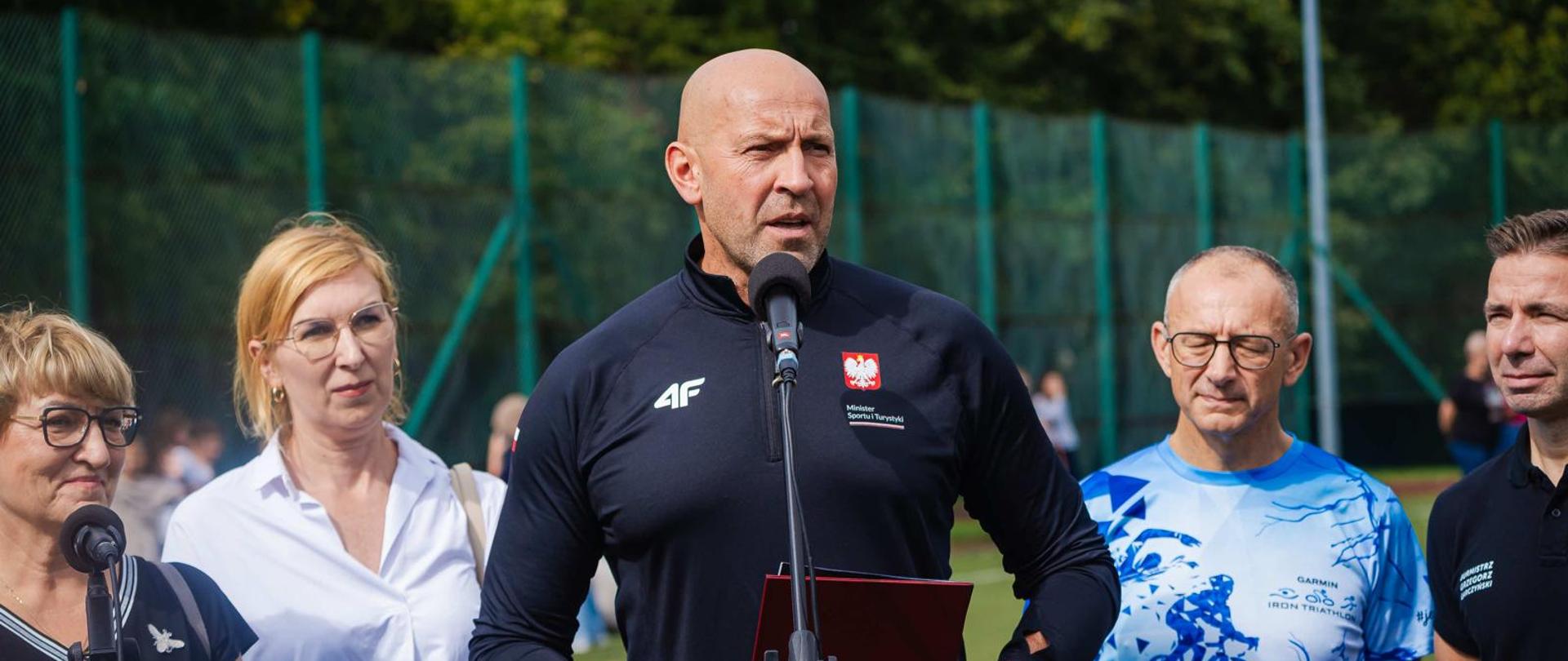 Konferencja prasowa. Za mikrofonem stoi minister sportu i turystyki Jakub Rutnicki. Po jego obu stronach, nieco z tyłu pozostali uczestnicy konferencji.