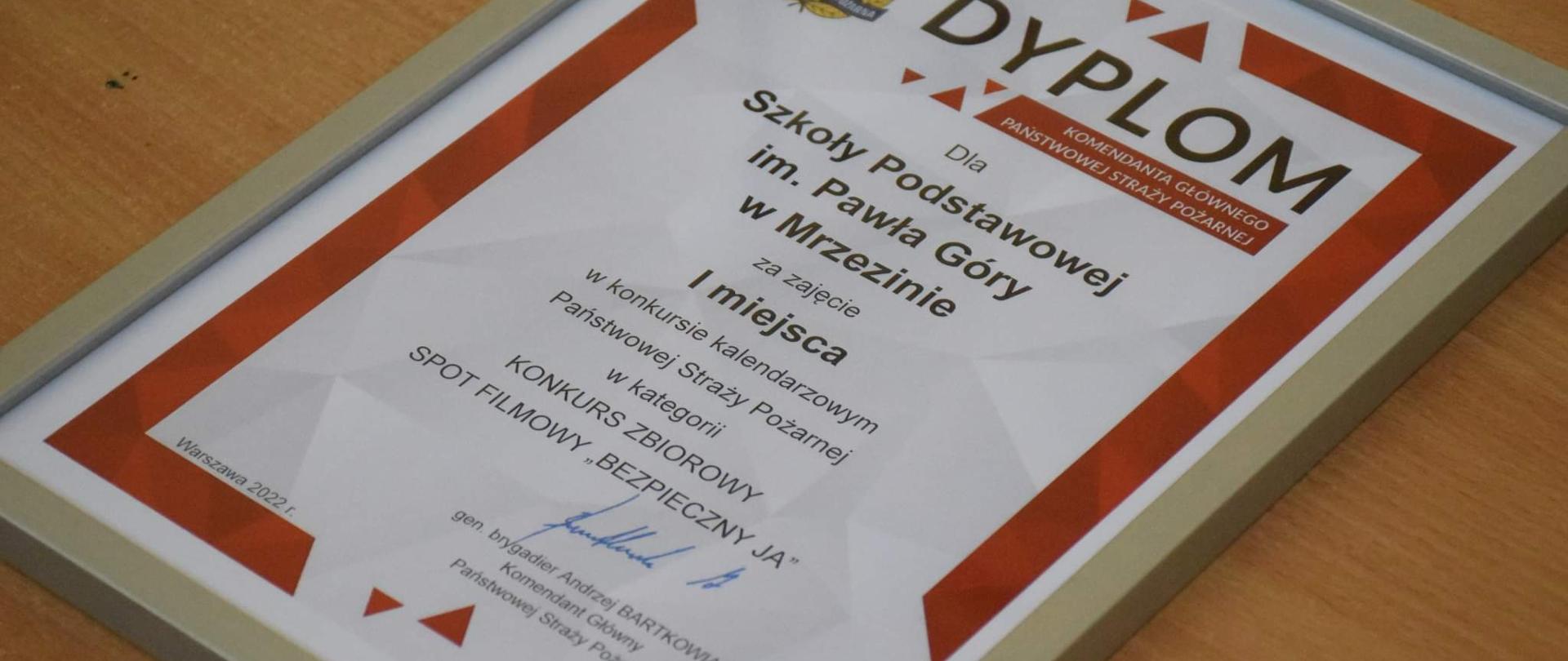 Zdjęcie przedstawia dyplom komendanta głównego PSP gen. brygadiera Andrzeja Bartkowiaka