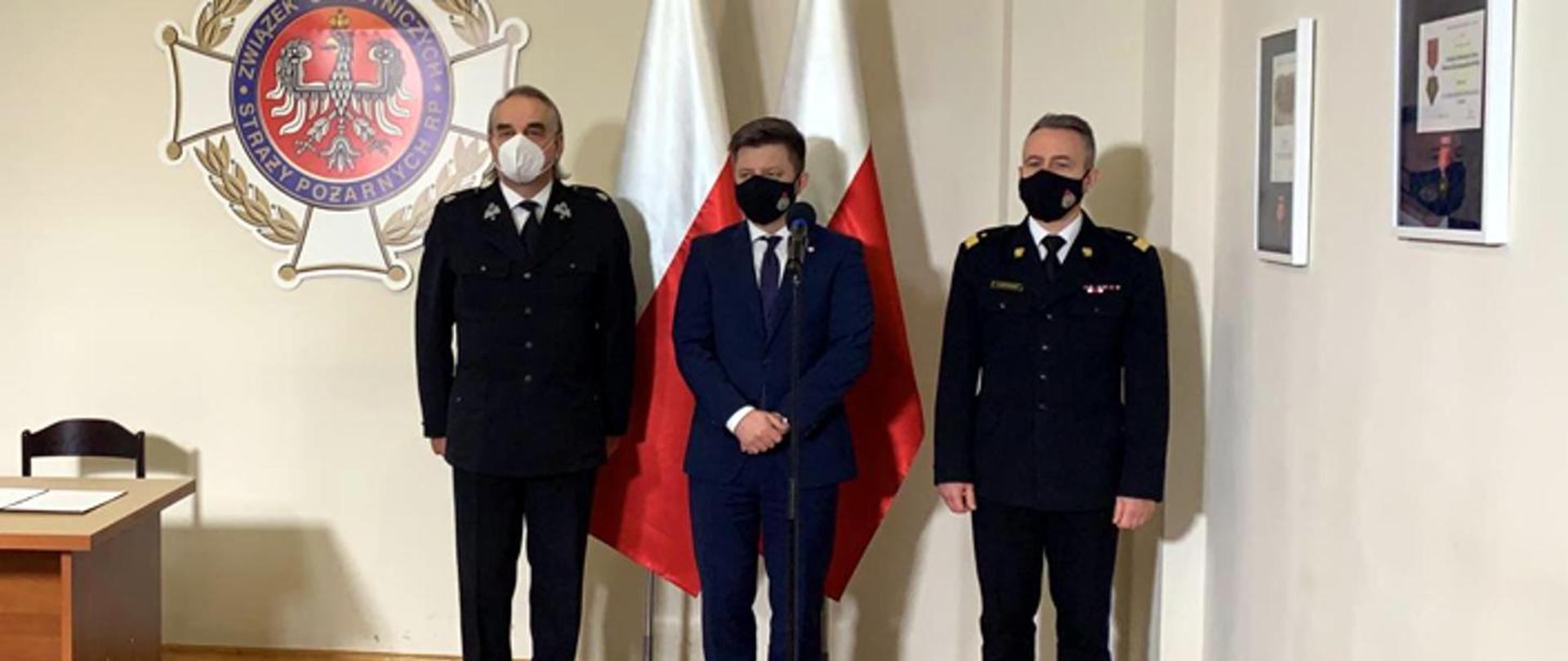 Foto przedstawia członków spotkania w siedzibie Zarządu Głównego Związku Ochotniczych Straży Pożarnych Rzeczypospolitej Polskiej. Michała Dworczyka, szefa Kancelarii Prezesa Rady Ministrów z nadbryg. Andrzeja Bartkowiaka, komendanta głównego PSP i dh. Waldemara Pawlaka prezesa ZG ZOSP RP.