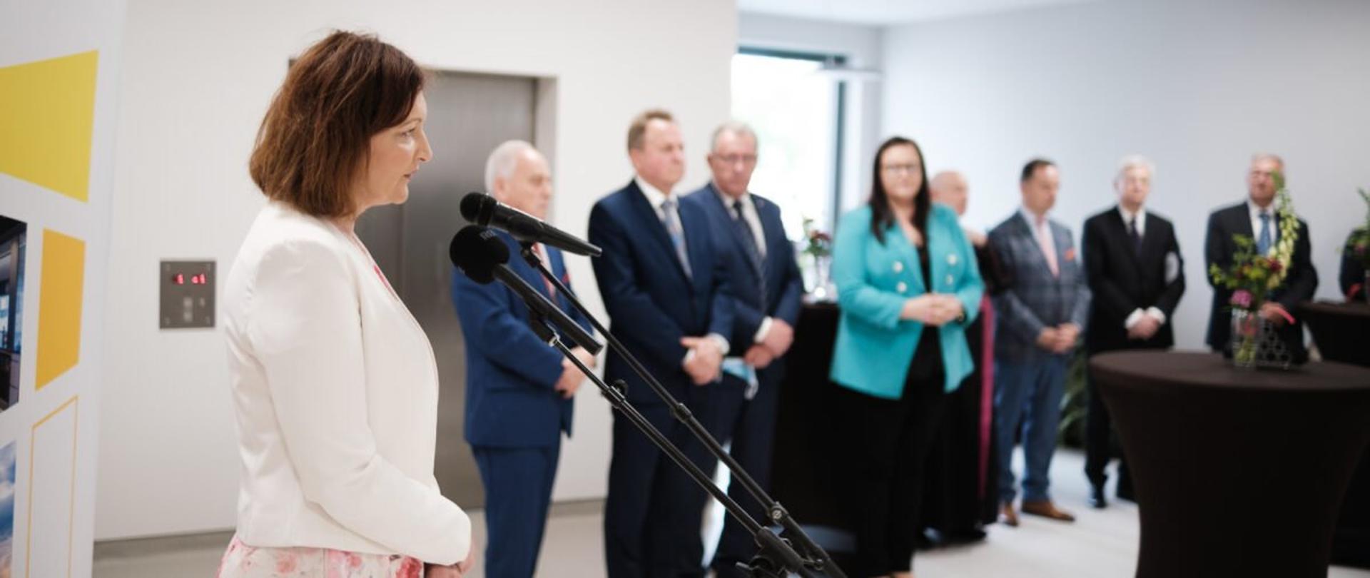 Wojewoda podkarpacki Ewa Leniart przemawia podczas otwarcia nowego budynku Podkarpackiego Centrum Chorób Płuc. W tle inni uczestnicy uroczystości